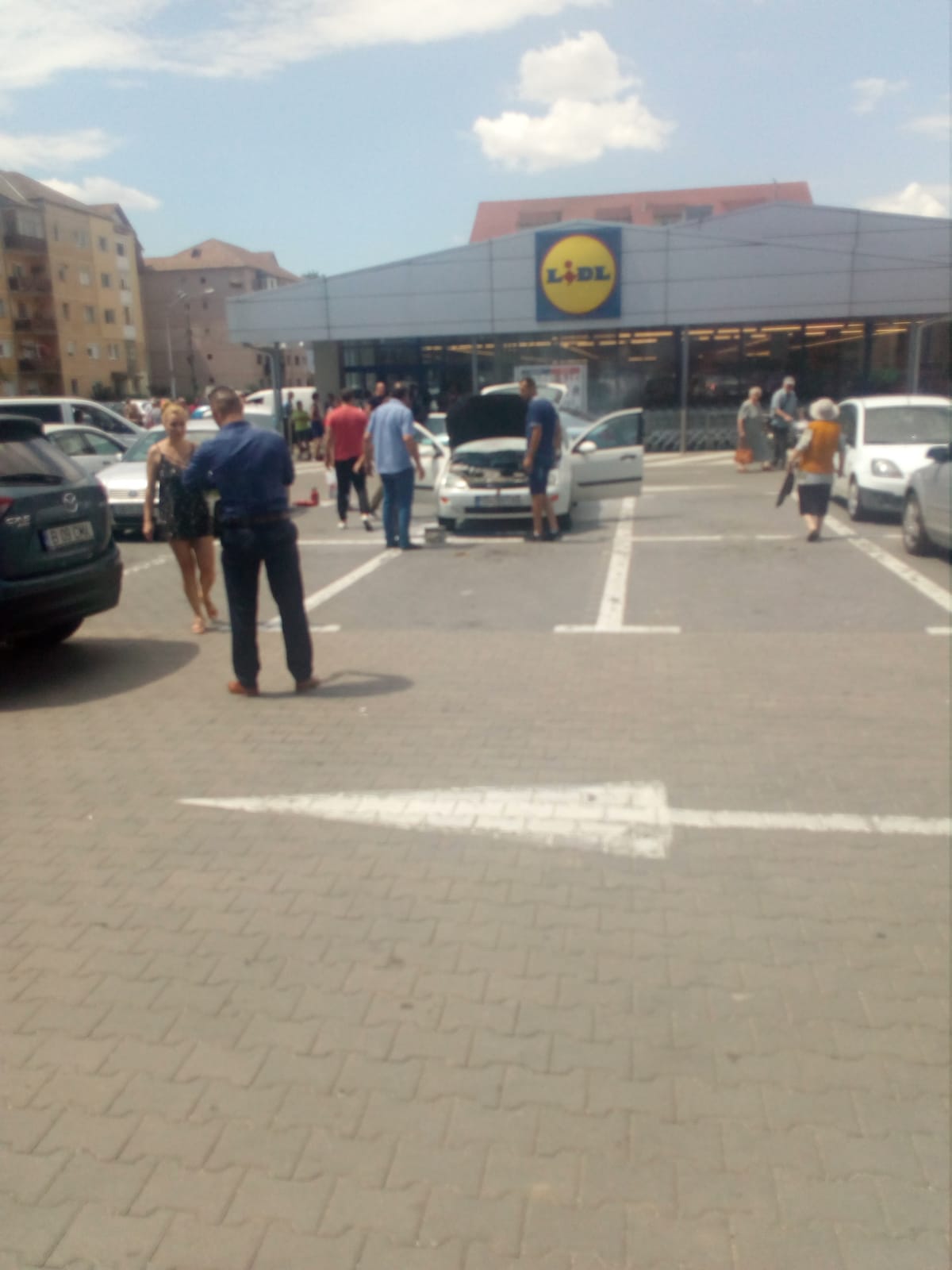 FOTO: O mașină a luat foc în parcarea unui supermarket