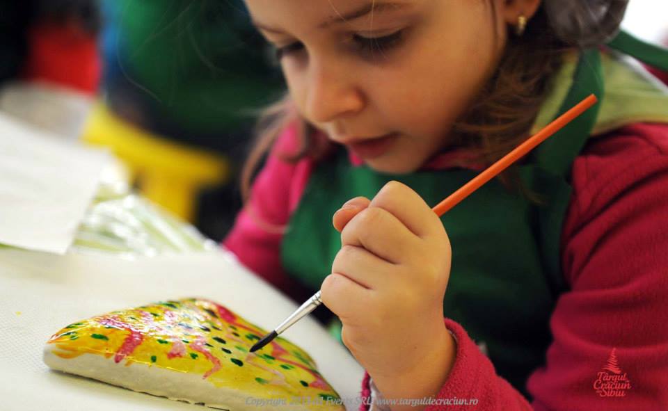 Copiii pictează turtă dulce, la Târgul de Crăciun